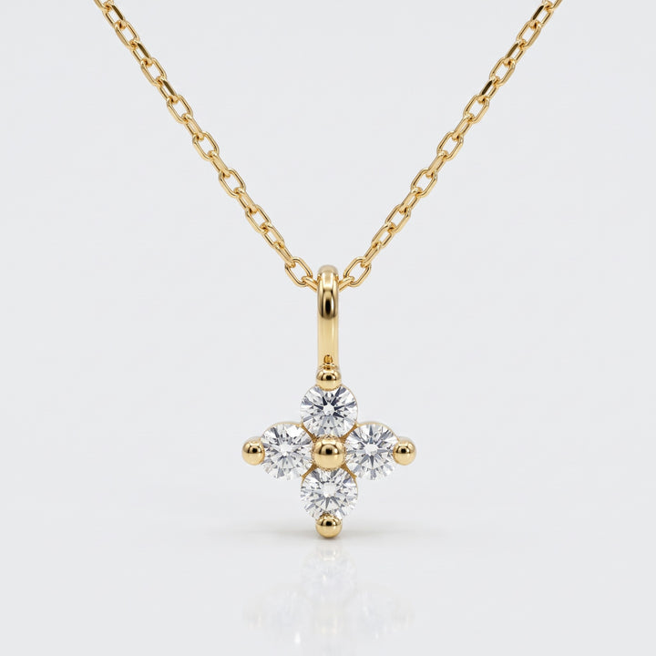 Delicate four natural diamond flower pendant in 14K yellow gold with chain — front view