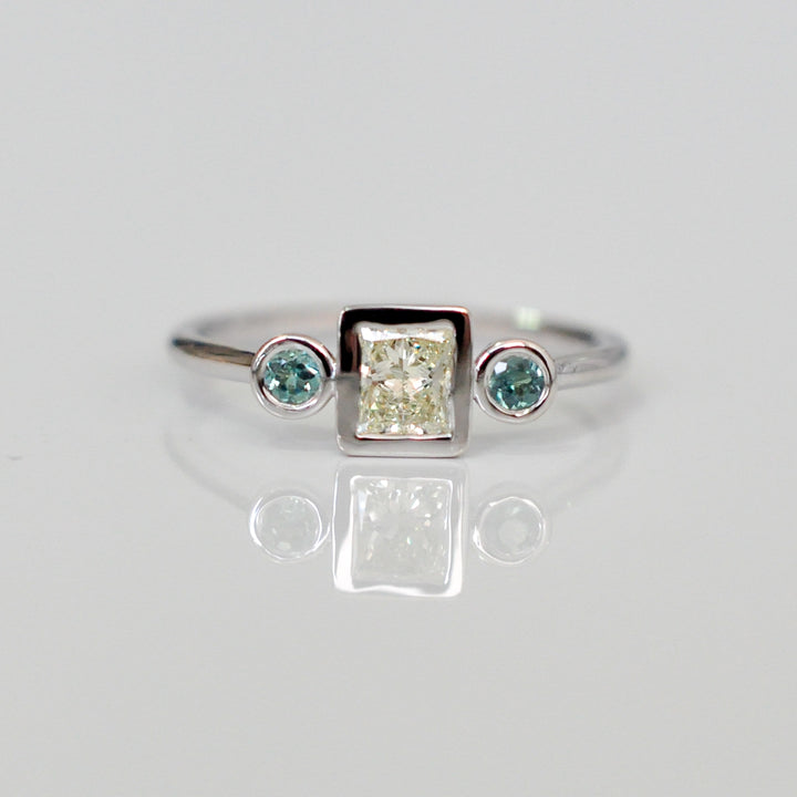 טבעת עם יהלום פרינסס ושני אמרלדים