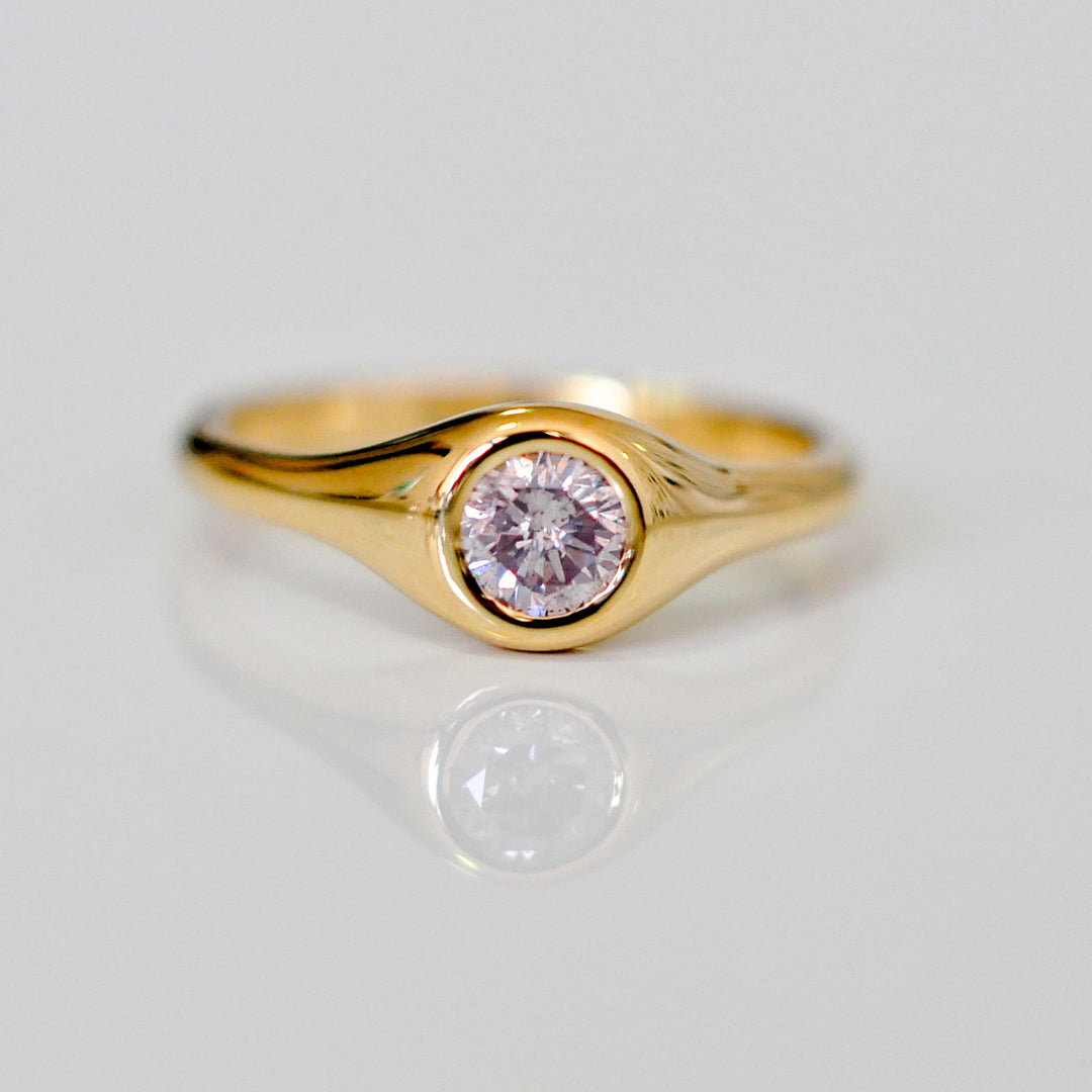 Faint pink diamond bezel set yellow gold ring